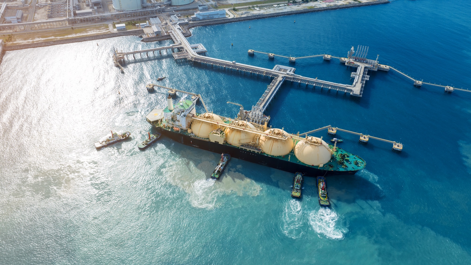 LNG (Liquefied natural gas) tanker anchored in Gas terminal gas tanks for storage. Oil Crude Gas Tanker Ship. LPG at Tanker Bay Petroleum Chemical or Methane freighter export import transportation